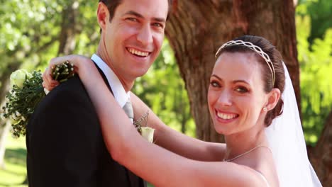 newlyweds dancing together and smiling at camera