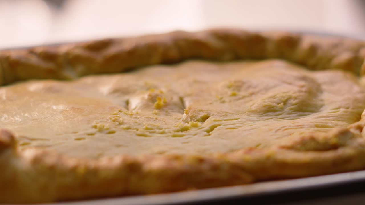 Slow Moving Shot of Homemade Deep Filled Shortcrust Chicken Mushroom Vegetable Pie After Being Cooked in Oven with Golden Crimped Pastry. Comforting British Tasty Delicious Food.