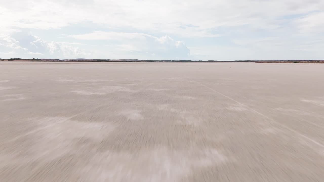 Aerial view of a vast saltwater lagoon in Sardinia, Italy. Surrounded by wild nature, this serene wetland is a haven for birdwatching and natural beauty, ideal for nature footage.