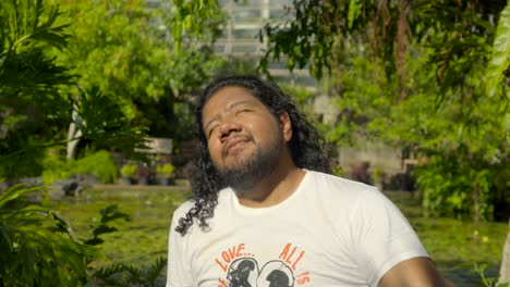 latin male bodypositive lgbtq young man enjoy peaceful happiness relaxation zen greenhouse garden at tropical dream center okinawa naha prefecture japan