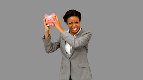 Businesswoman-listening-to-an-empty-piggy-bank-on-grey-screen