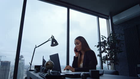 business woman answering on phone call. female freelancer working on laptop