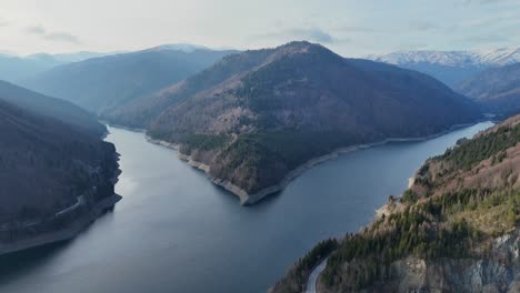 Serene-aerial-view-of-Rausor-Lake-winding-through-the-lush,-mountainous-landscape