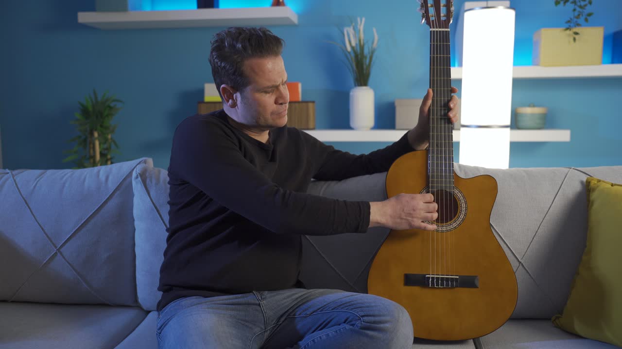 밤늦게 기타를 연주하는 성인 남자가 우울하고 외롭습니다.