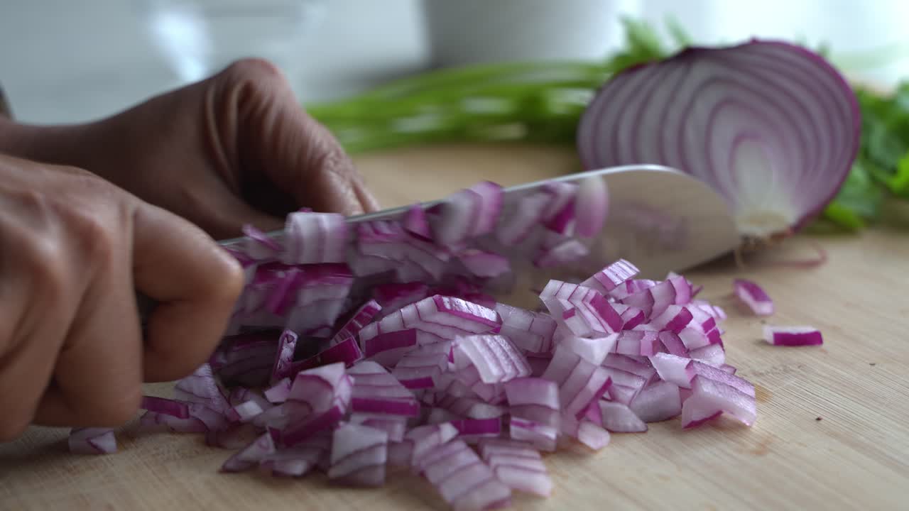Close up of Cutting red onions and special ingredients to cook a meal two cans of beans rice plantain avocado red onion and cilantro
