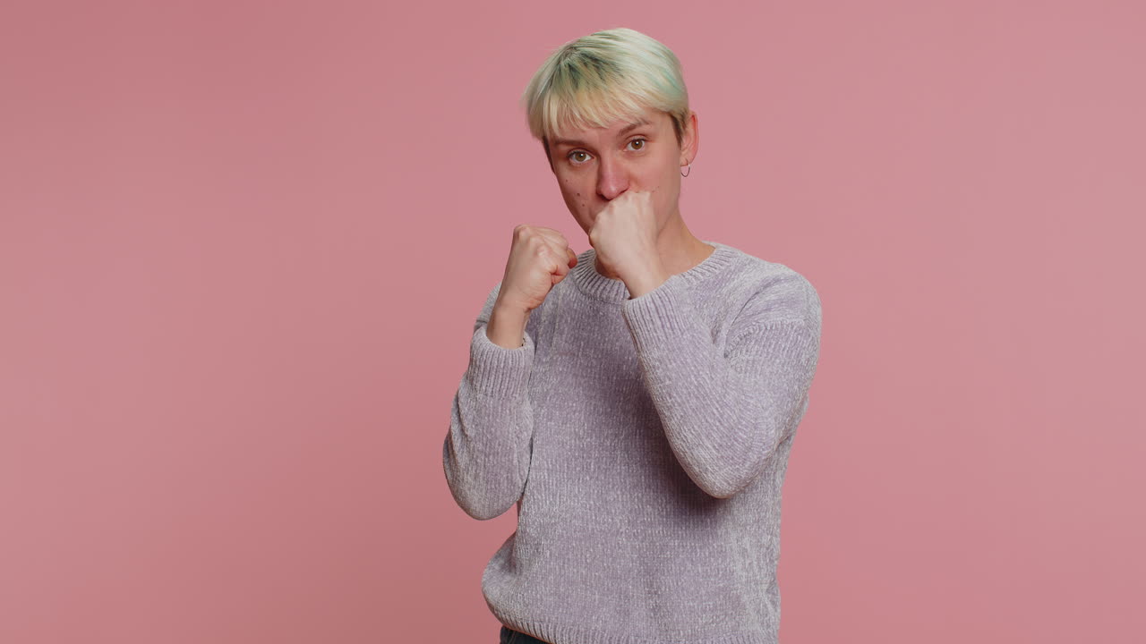 mujer agresiva y enojada tratando de pelear ante la cámara, sacudiendo el puño, boxeando con expresión, castigo