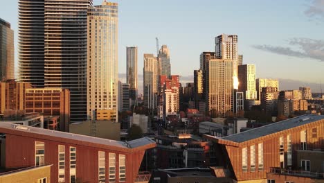 descending aerial view of illuminated skyscraper buildings and luxury apartments in first row of canary wharf district,london
