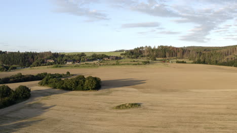 Aerial-Shot-Of-Agricultural-Farm-Land-Surrounded-By-Forest-At-Sunrise,-Czech-Republic