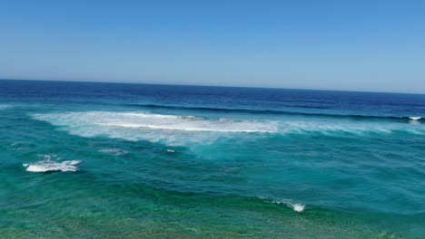 Cofete-beach,-Fuerteventura:-aerial-view-traveling-in-to-the-shore-of-the-great-beach-and-the-breaking-waves