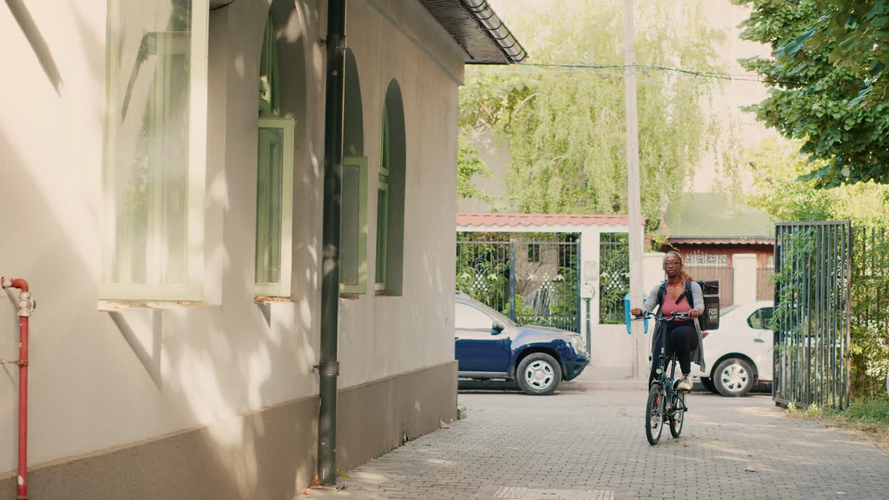 Woman riding a bicycle for food delivery on a street