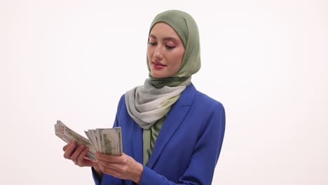 Young Muslim Woman in Hijab Counting US Dollar Bills