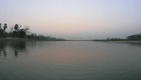 cruising through a bangladeshi river during the sunset with no one in sight.