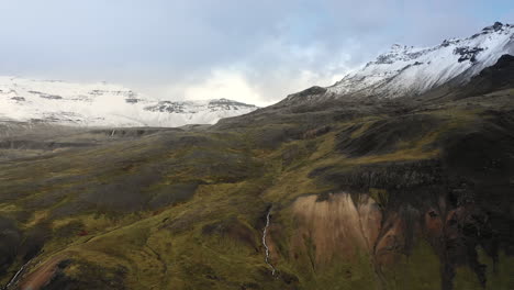 Drone-flight-towards-snow-covered-peaks-in-Iceland