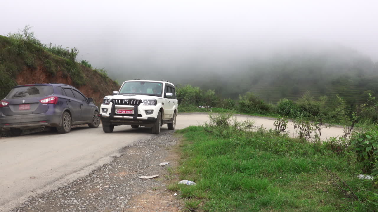 Kathmandu, Nepal - September 27, 2019: Traffic and vehicles on a dangerous, muddy mountain road in the foothills of Kathmandu, Nepal on September 27, 2019.