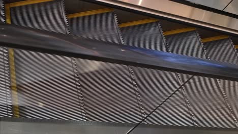 an empty escalator moving downwards inside a commercial centre in a business area in southeast asia