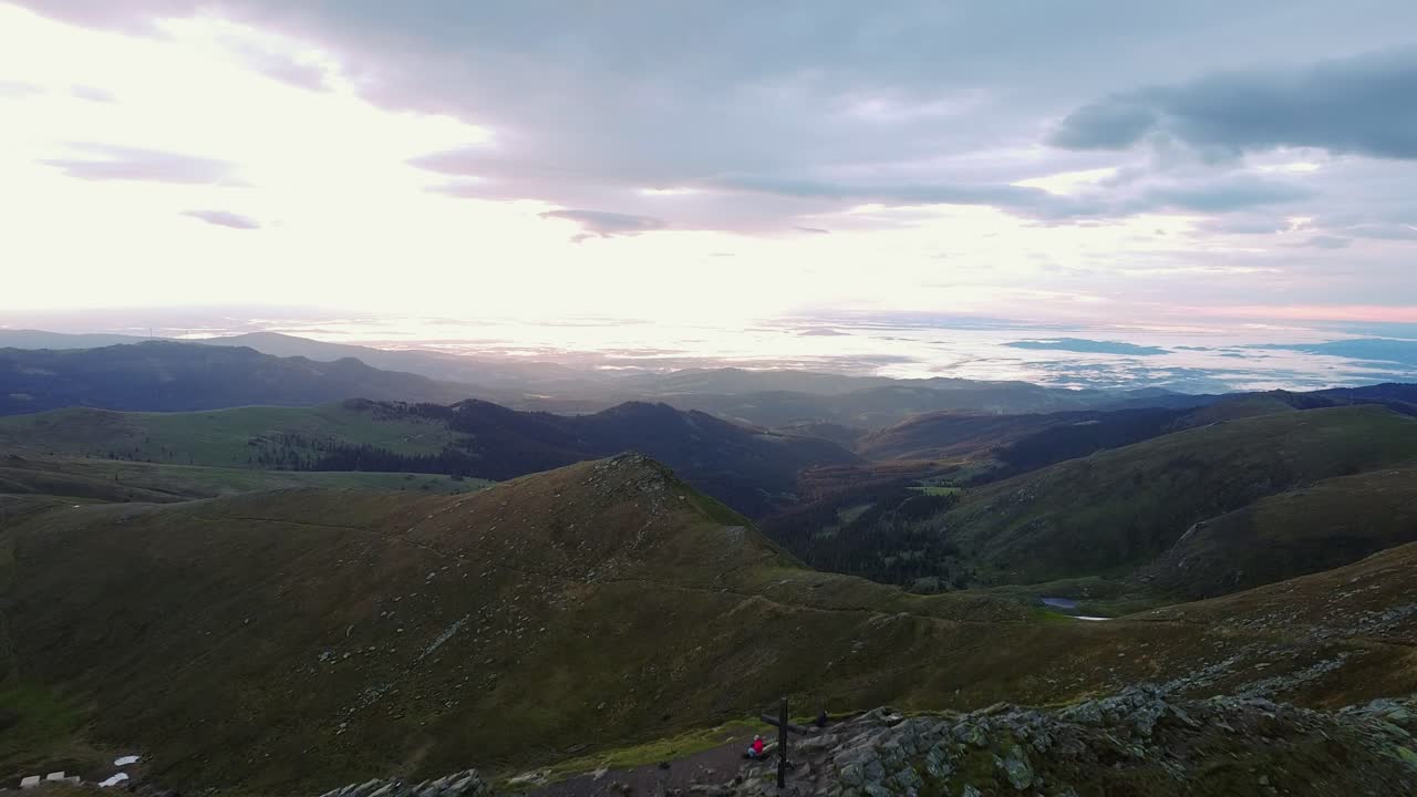 una impresionante vista aérea de un amanecer de montaña, mostrando un mar de nubes debajo