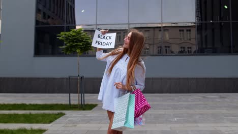 joyful teen girl showing black friday inscription, smiling, looking satisfied with low prices