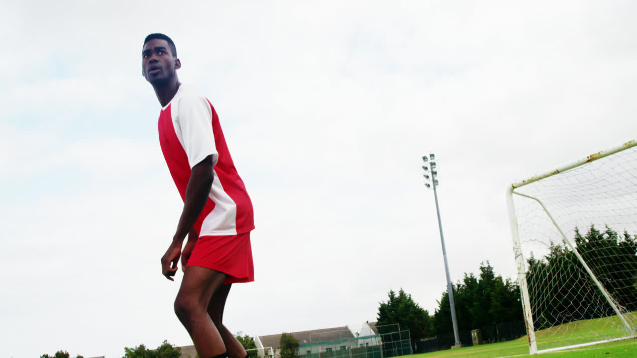 jugador de fútbol golpeando una pelota en el campo