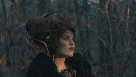 mysterious woman in black coat with messy hair wandering around the forest - slow motion