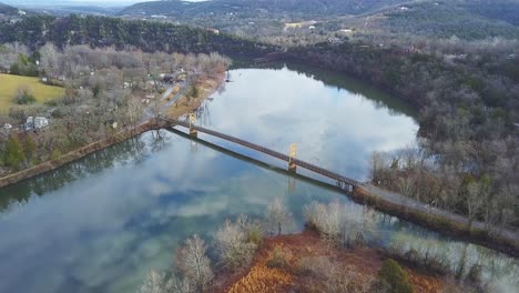 Puente-Sobre-El-Río-Con-Reflejos-De-Nubes-En-La-Superficie