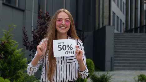 teen girl showing up to 50 percent off inscription, advertising discounts, shopping on black friday