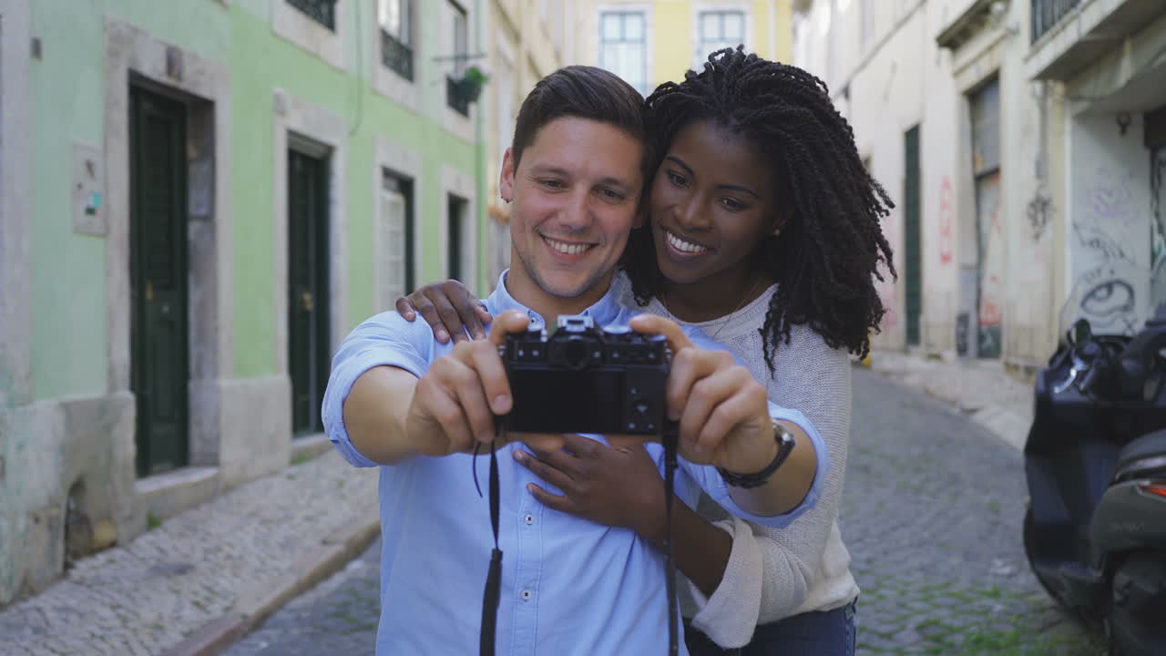 una pareja alegre y feliz tomando selfies con la cámara fotográfica.