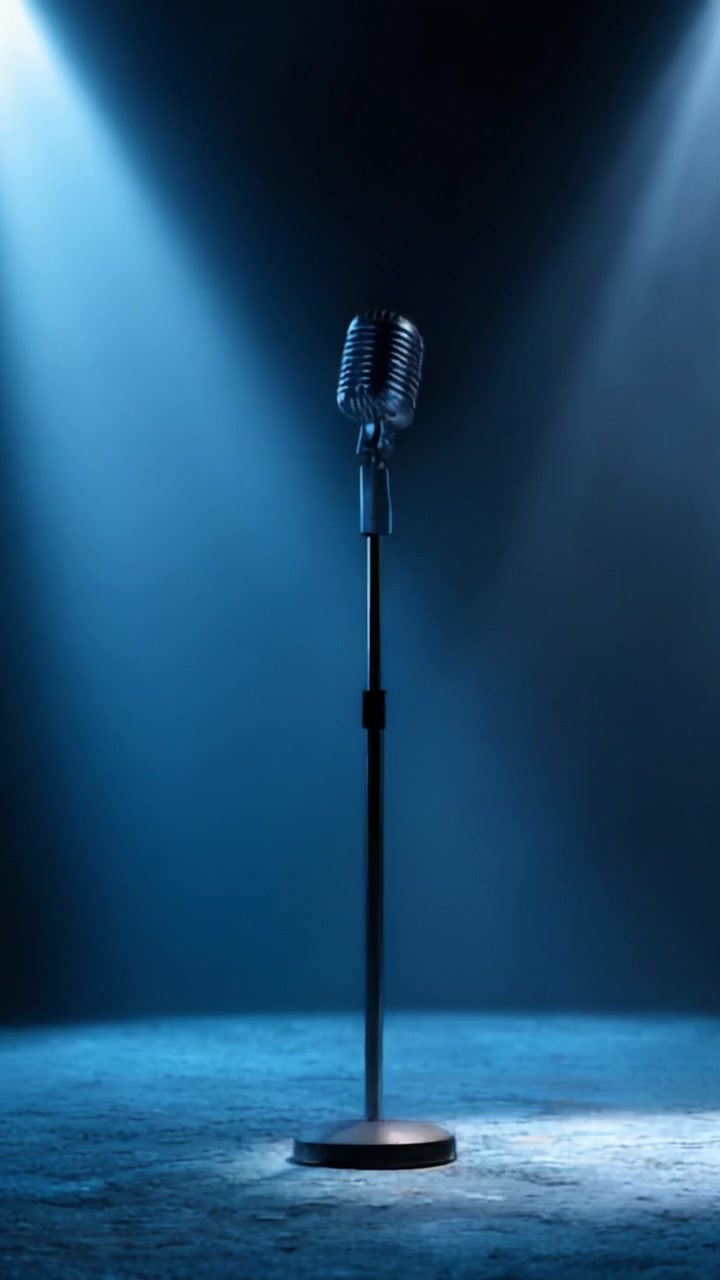 Un classico microfono retrò sta solo sul palco, immerso in luce blu, in attesa del suo artista per un'accattivante performance musicale o un discorso.