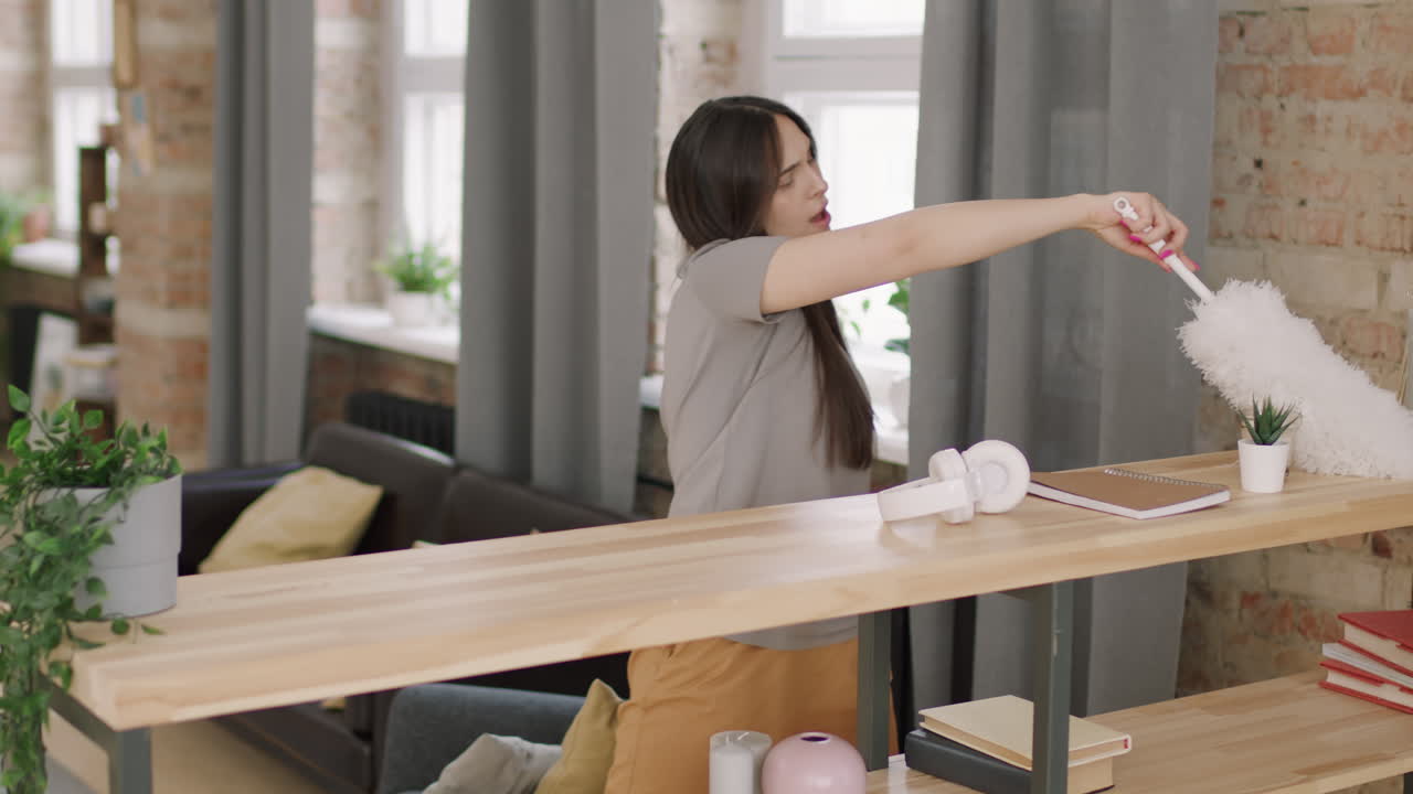 Beautiful Young Woman Dusting and Singing