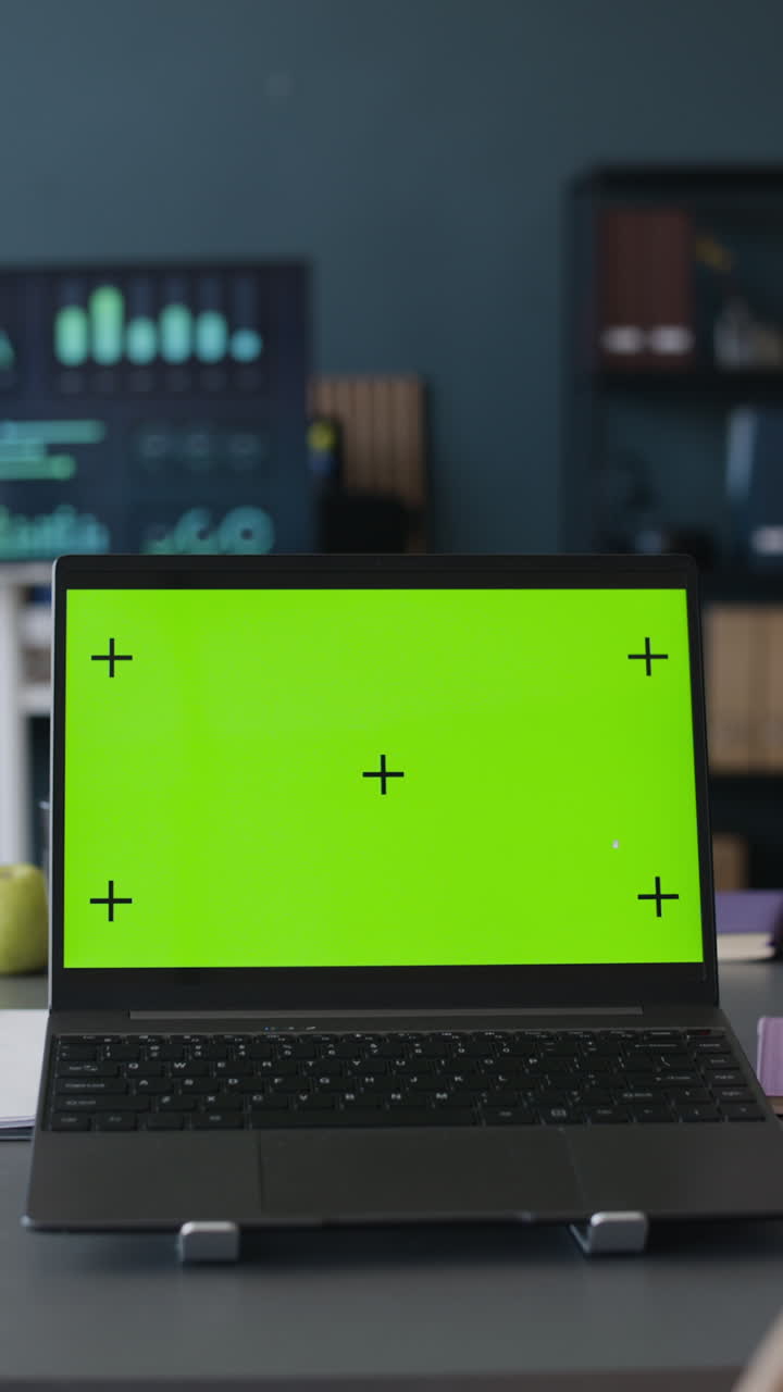 Laptop with green screen in an office setting
