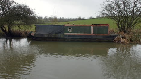 Ein-Altes-Schmales-Kanalhausboot,-Das-Auf-Einem-Fluss-In-England-Verlassen-Wurde