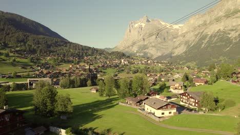 dolly-sideways-left-to-right-of-ascending-cabin-of-tricable-car-system-Eiger-Express-in-Grindelwald-in-front-of-Mount-Wetterhorn