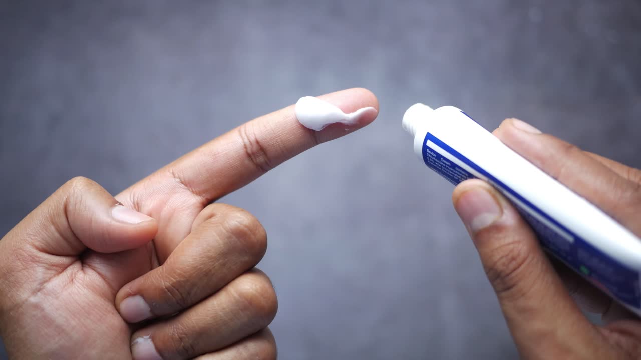 la aplicación de crema en el dedo