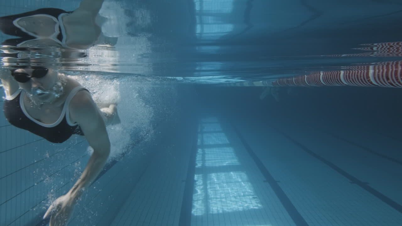 Underwater Shot Of A Young Female Swimming In The Pool In The Direction Of The Camera