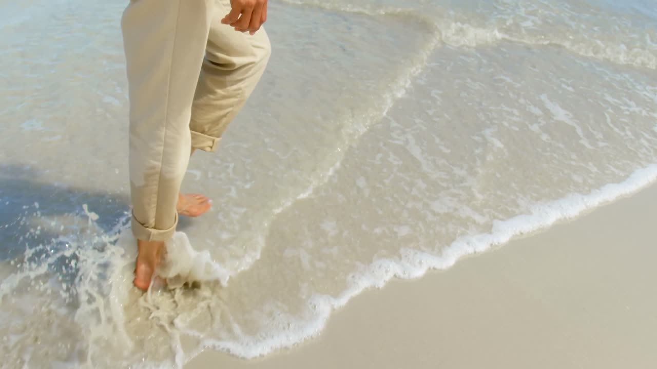 활동적인 시니어 아프리카계 미국인 여성의 낮은 섹션은  ⁇ 빛 4k에서 해변에서  ⁇ 고