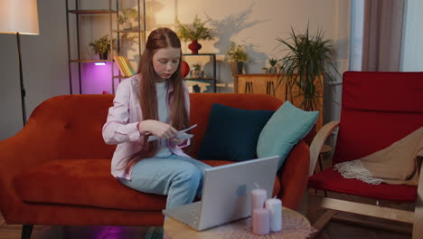 stressed child girl looking at unpaid bank debt loan, doing paperwork, planning budget, throws bills