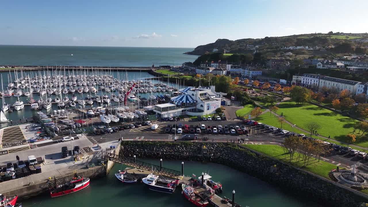Howth marina with boats and park on waterfront, sunny autumn day. Dublin Ireland, drone