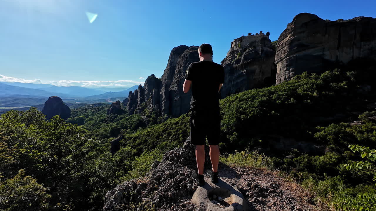 절벽 가장자리에 서서 사진을 찍는 남자