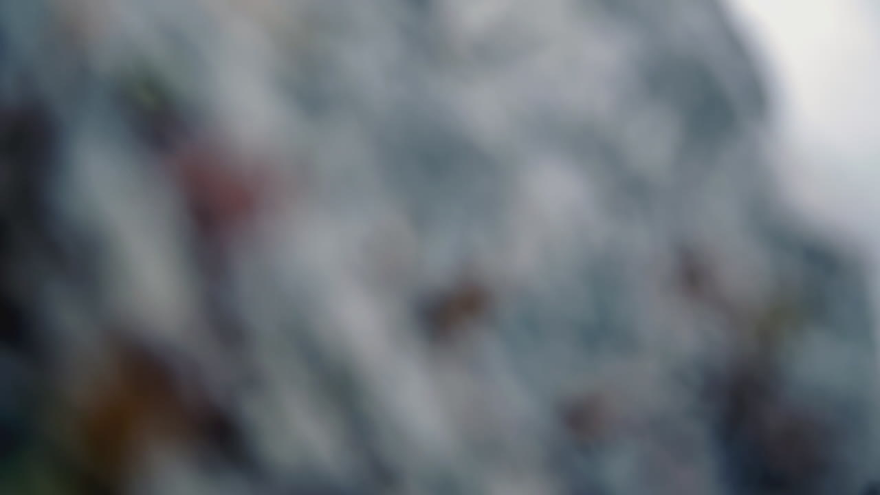 personas de pie cerca de una gran formación rocosa en un día nublado