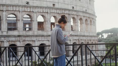 woman taking photo of the colosseum in rome