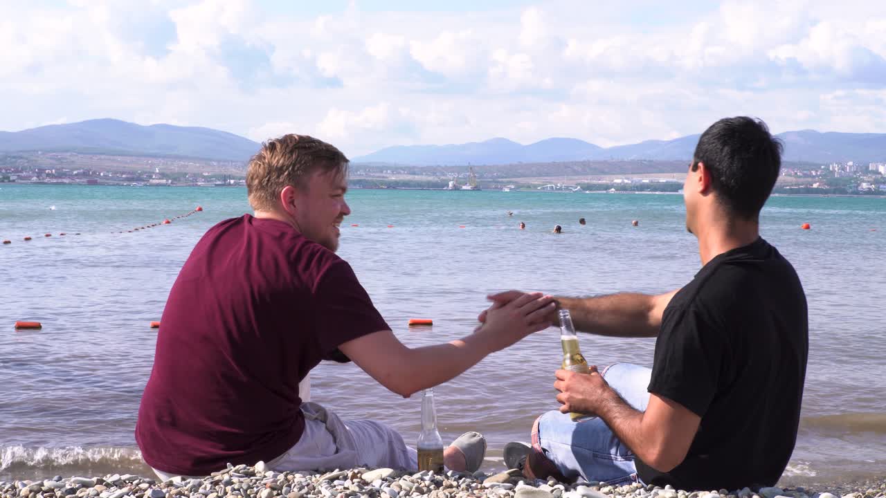 남자들이 해변에서 휴식을 취하고 대화하고 있습니다.