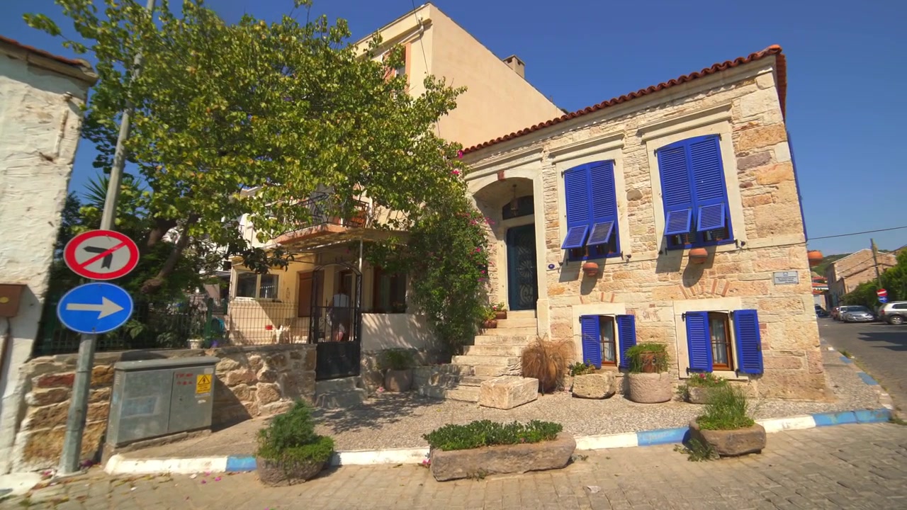 Case tradizionali in pietra con persiane blu in un villaggio mediterraneo