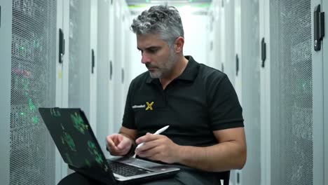 a professional technologist analyzing data in a server room while sitting on a chair with a laptop and notepad, surrounded by server racks and indicator lights