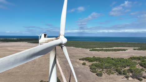 stationary drone shot of spinning wind turbine