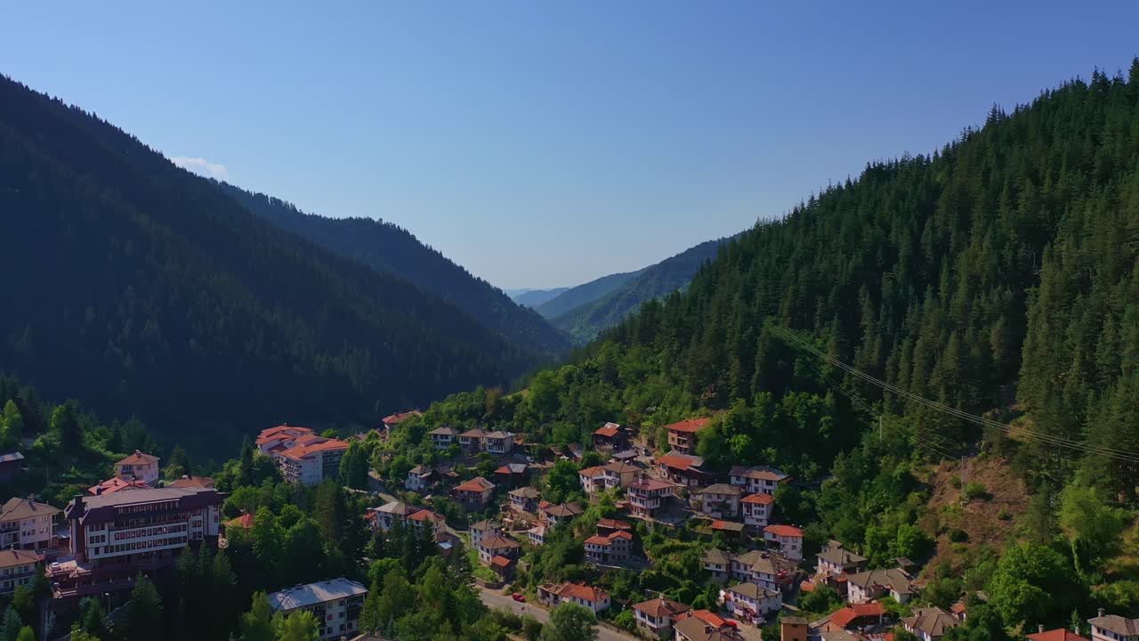 Flying over a small town surrounded by green hills in the mountains,Bulgaria Europe