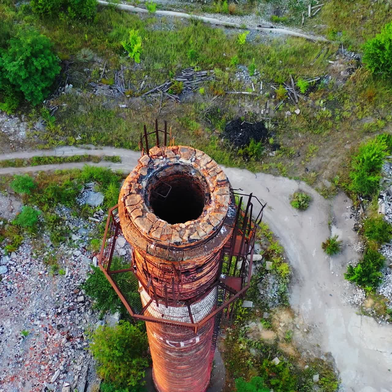 Old industrial chimney. Brick pipe of long built on the desolate factory position. Top aerial view.