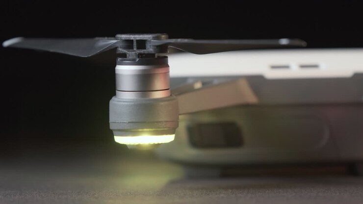 Kjøring over høyre side og propeller på en hvit DJI Spark-drone med blinkende dronelys