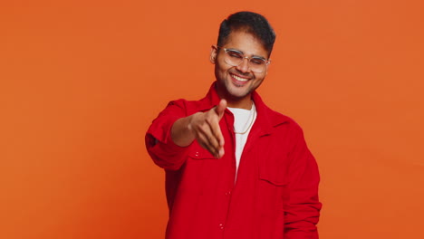friendly indian man outstretching hand to camera offering handshake greeting invitation welcoming