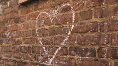 heart drawn in chalk on brick wall - handheld close