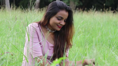 Hermosa-Mujer-India-Sentada-En-Un-Campo-De-Hierba-Alta