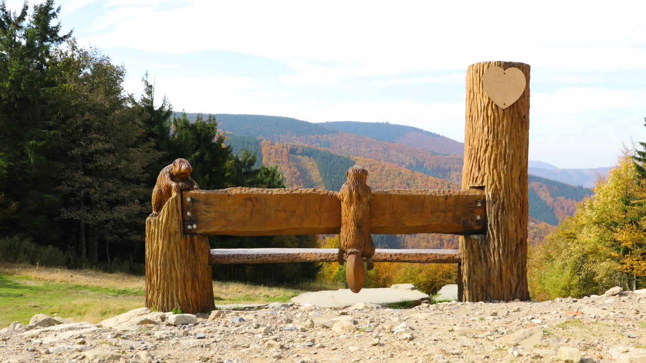 banco de madera para caminar con un símbolo de bondad en la cima de una montaña con vistas al campo abierto en la región de pustevny beskids 4k 60fps